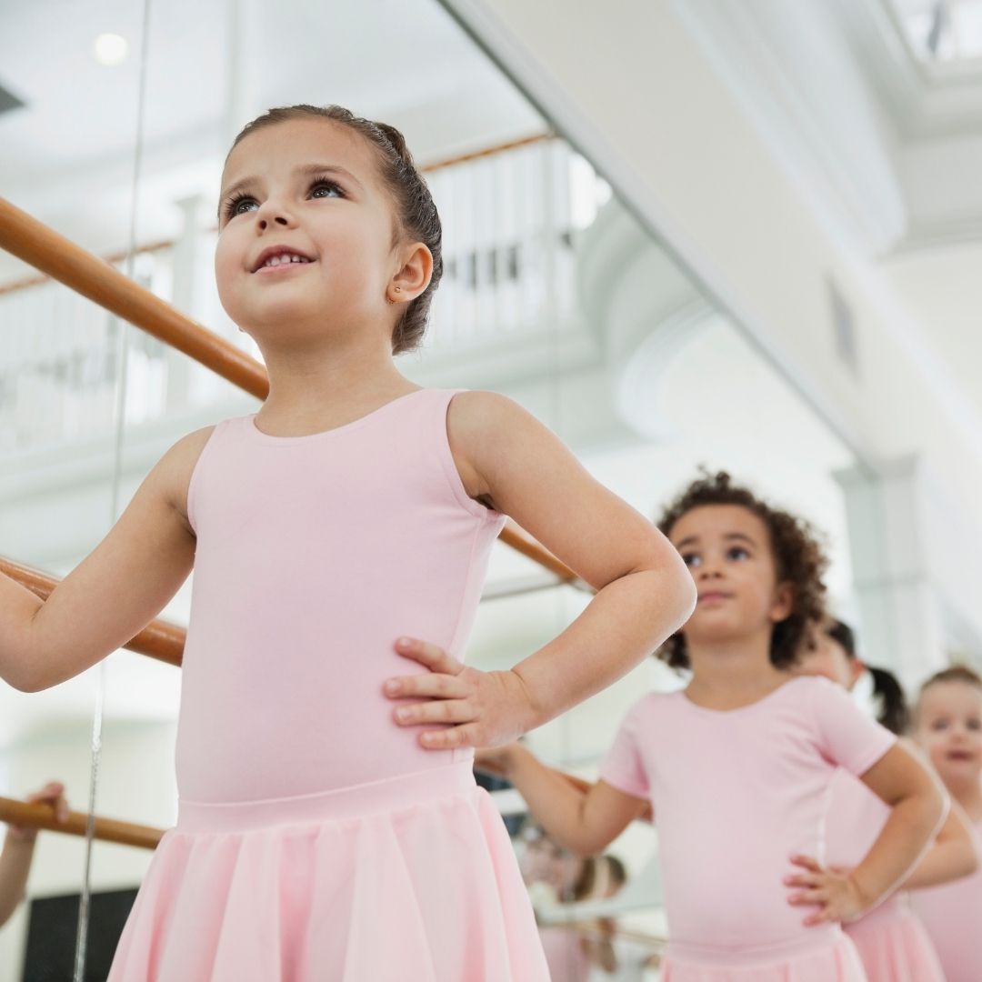 Kindergruppe in rosafarbenden Kleidern beim Tanztraining.