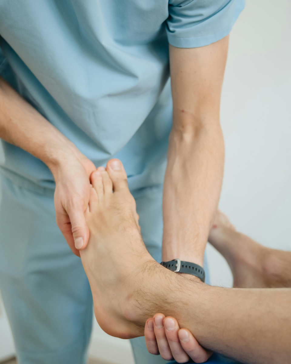 Ein Physiotherapeut bei der Behandlung eines Patienten mit Hallux valgus.